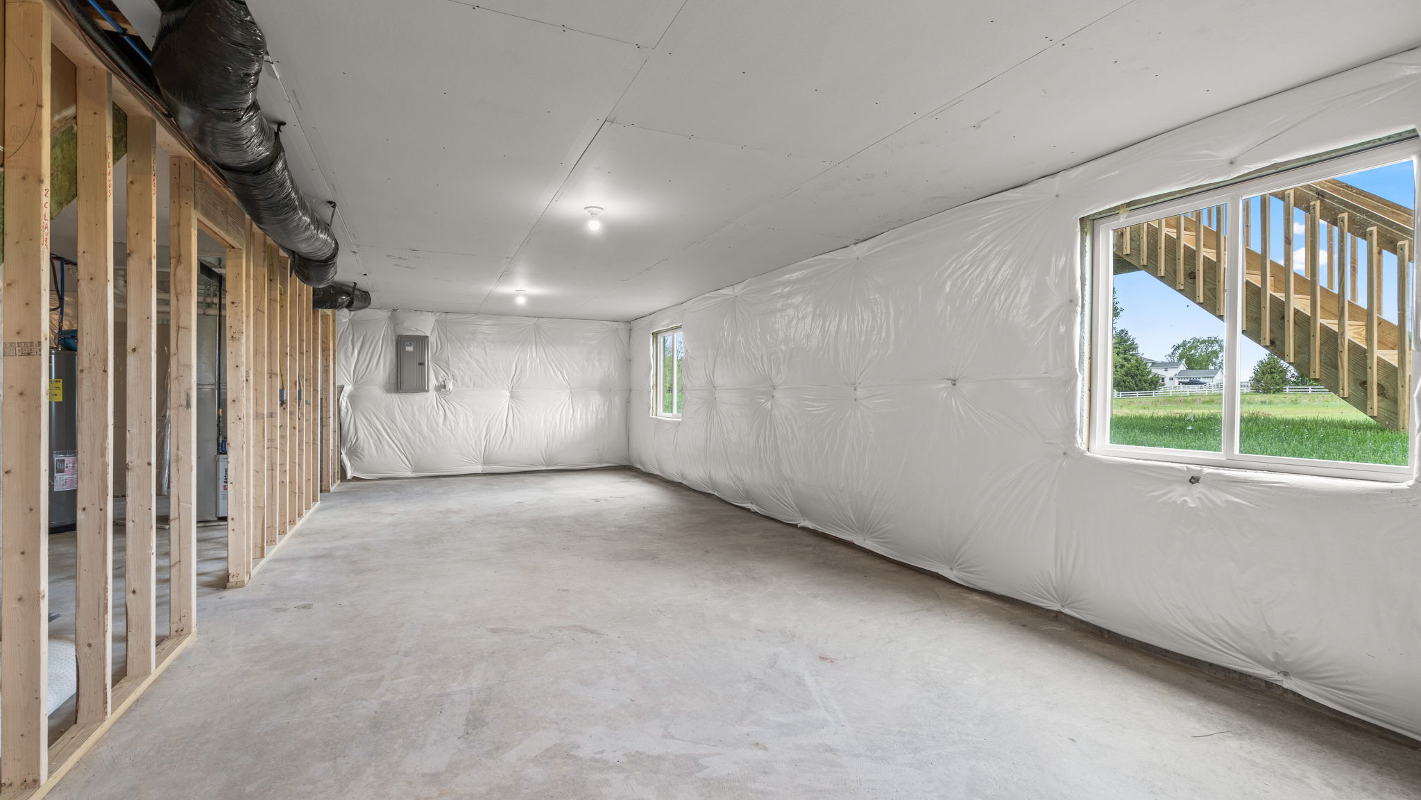 Basement with several windows and concrete flooring.