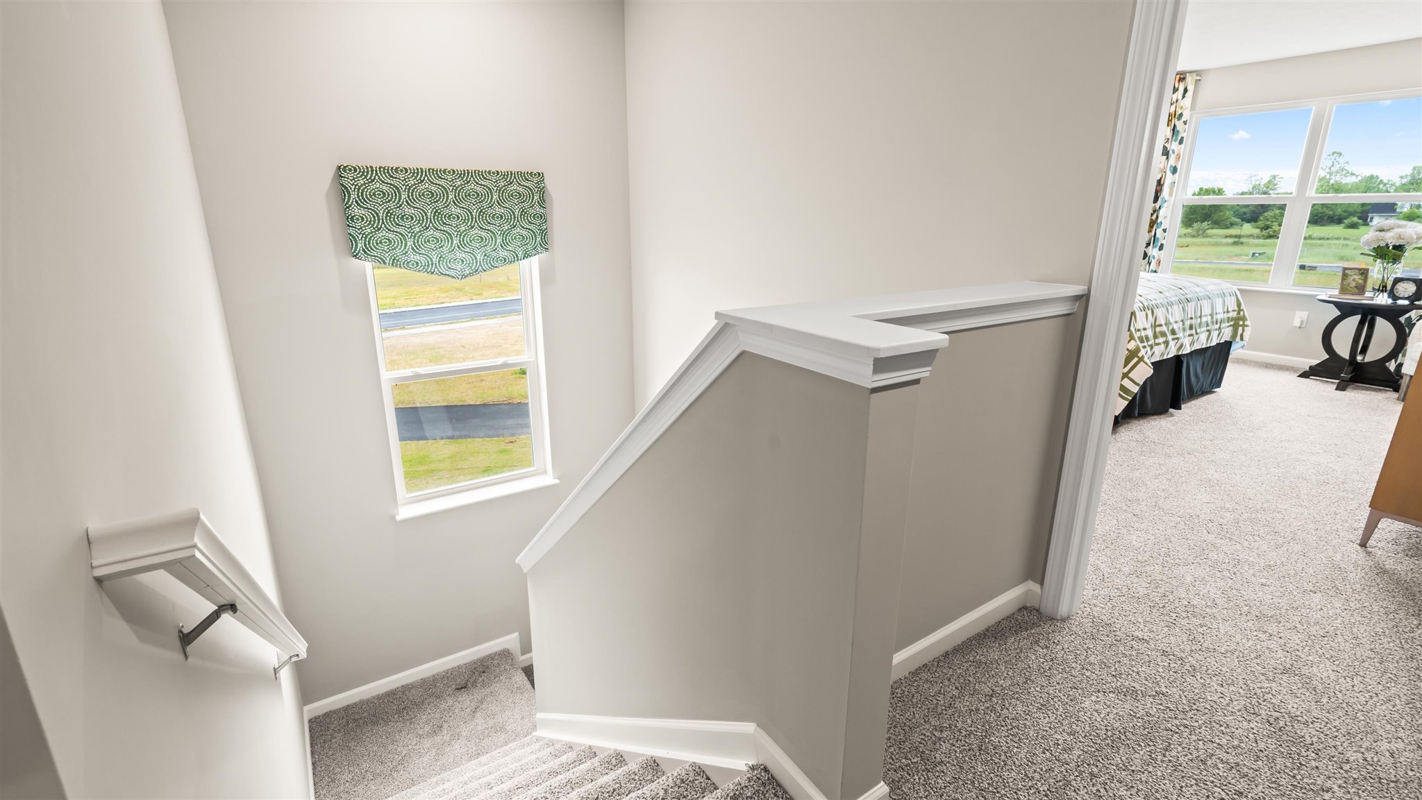 stair landing from second floor and view of primary bedroom.