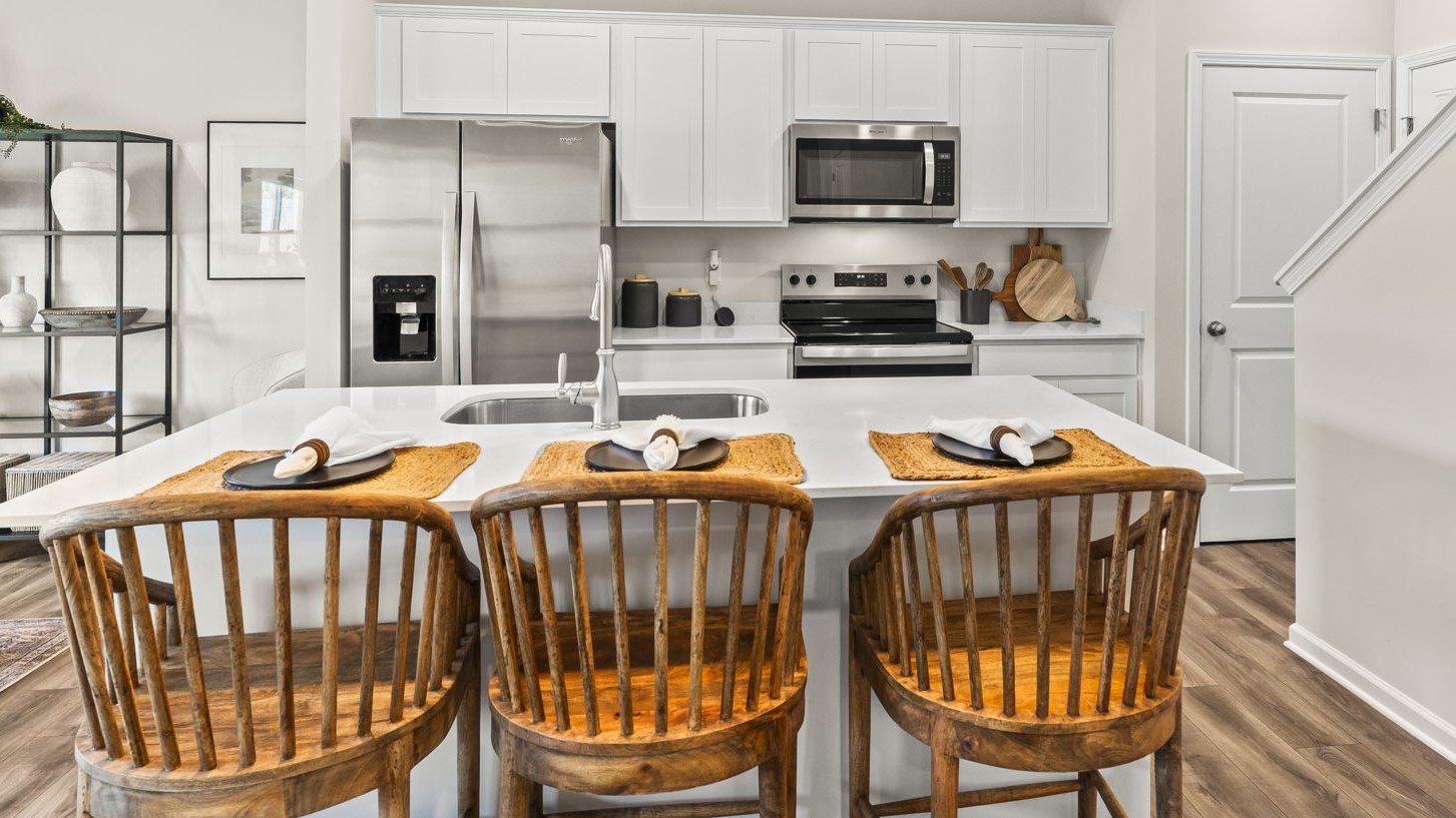 Kitchen island view of kitchen with white cabinetry and appliances