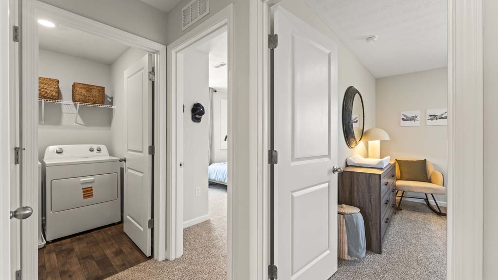 Upstairs hallway with perspective of laundry room and two of the bedrooms