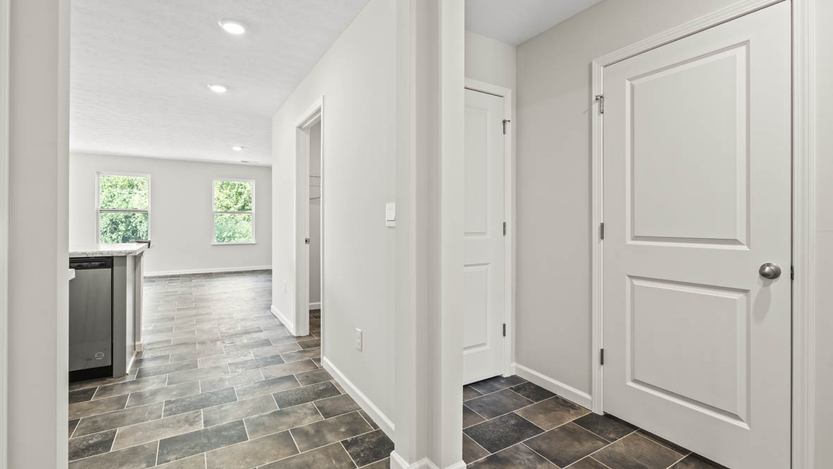 Hallway leading into the kitchen on the left side and bedrooms on the right