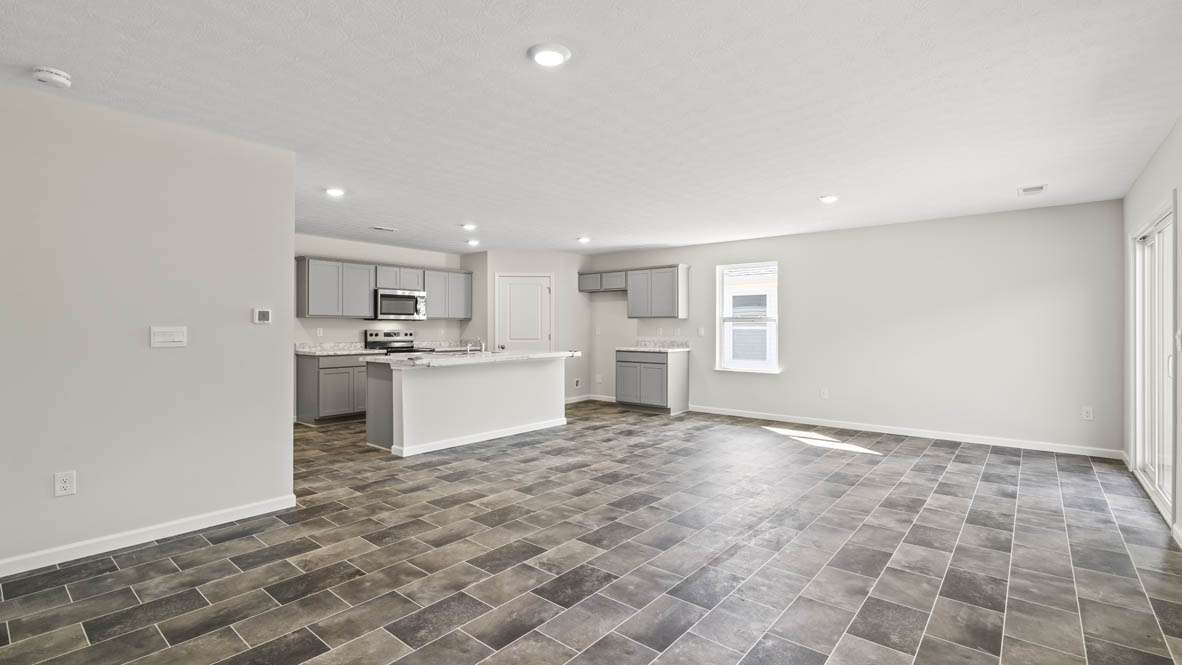 Great room with view of kitchen island, flooring, and window