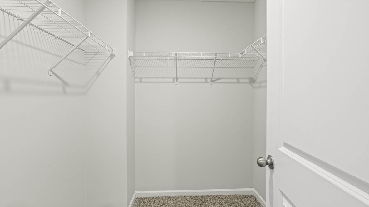 Walk-in closet with wire shelving in the primary suite