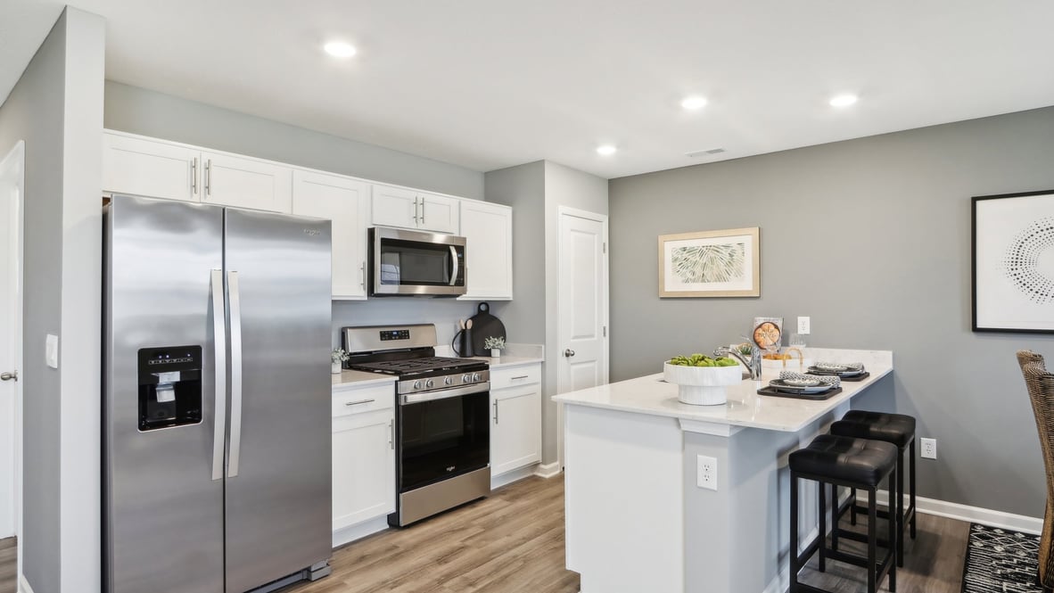 Open concept kitchen with white cabinets and kitchen cabinets.