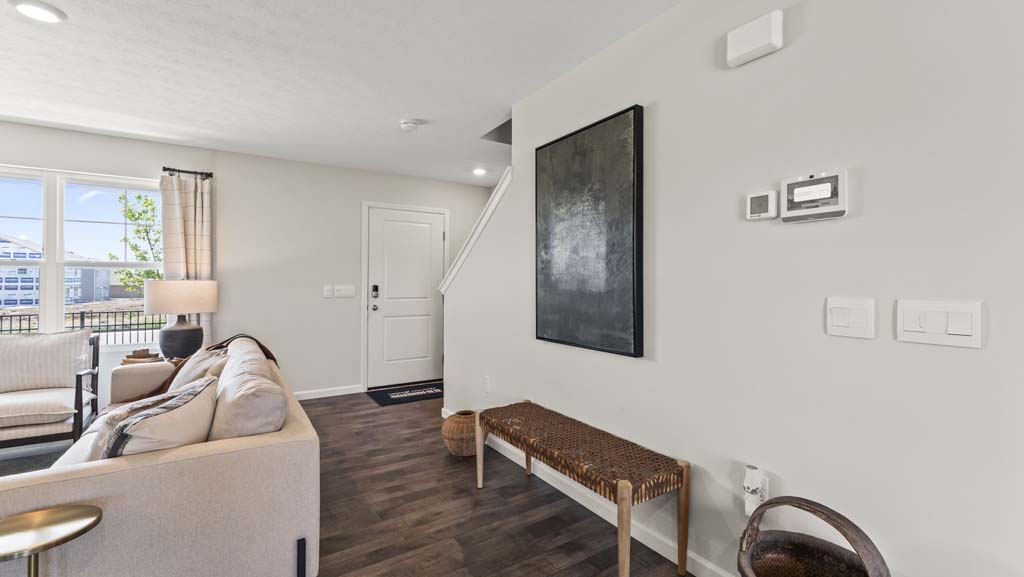 First floor foyer with front door visible alongside art and woven bench