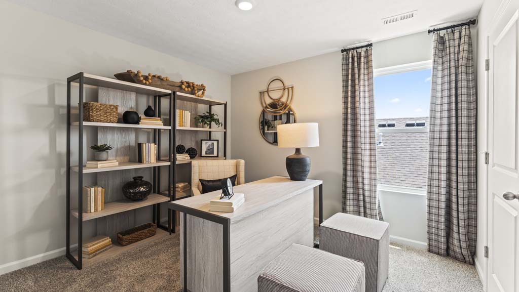 Flex room arranged as an office with brown and black pottery, baskets, and wooden table