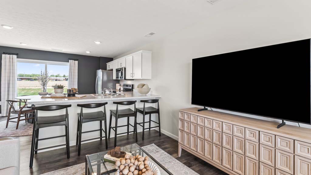 Closeup of living room tv with perspective of laminate kithen countertop and four chairs