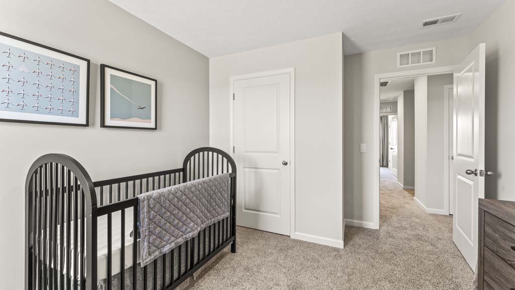 Bedroom with airplane-themed art, crib, and door to closet