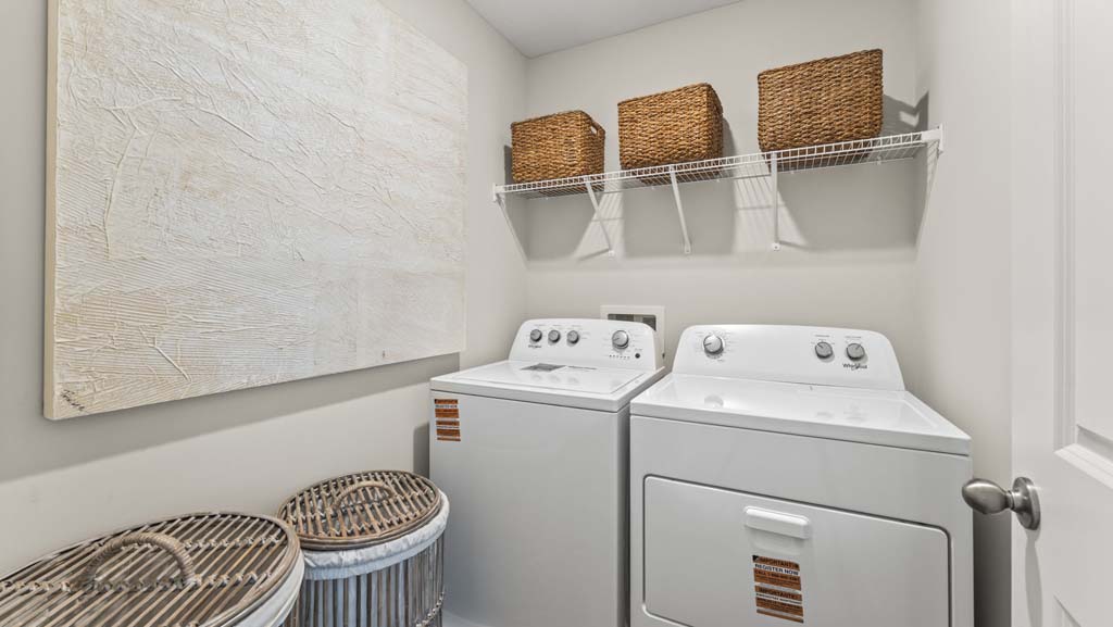 Laundry area with woven baskets on the side of the washing machine and ontop of the wire shelving above the laundry units