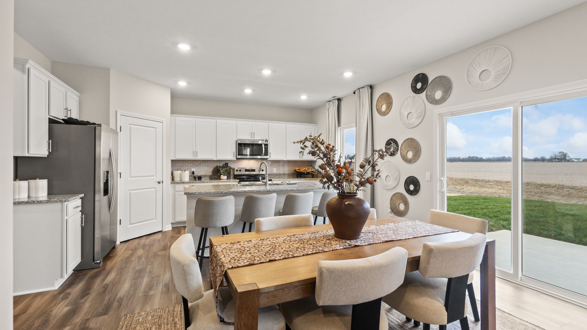 Open dining area with wooden table, floral decoration, and brown table runner.