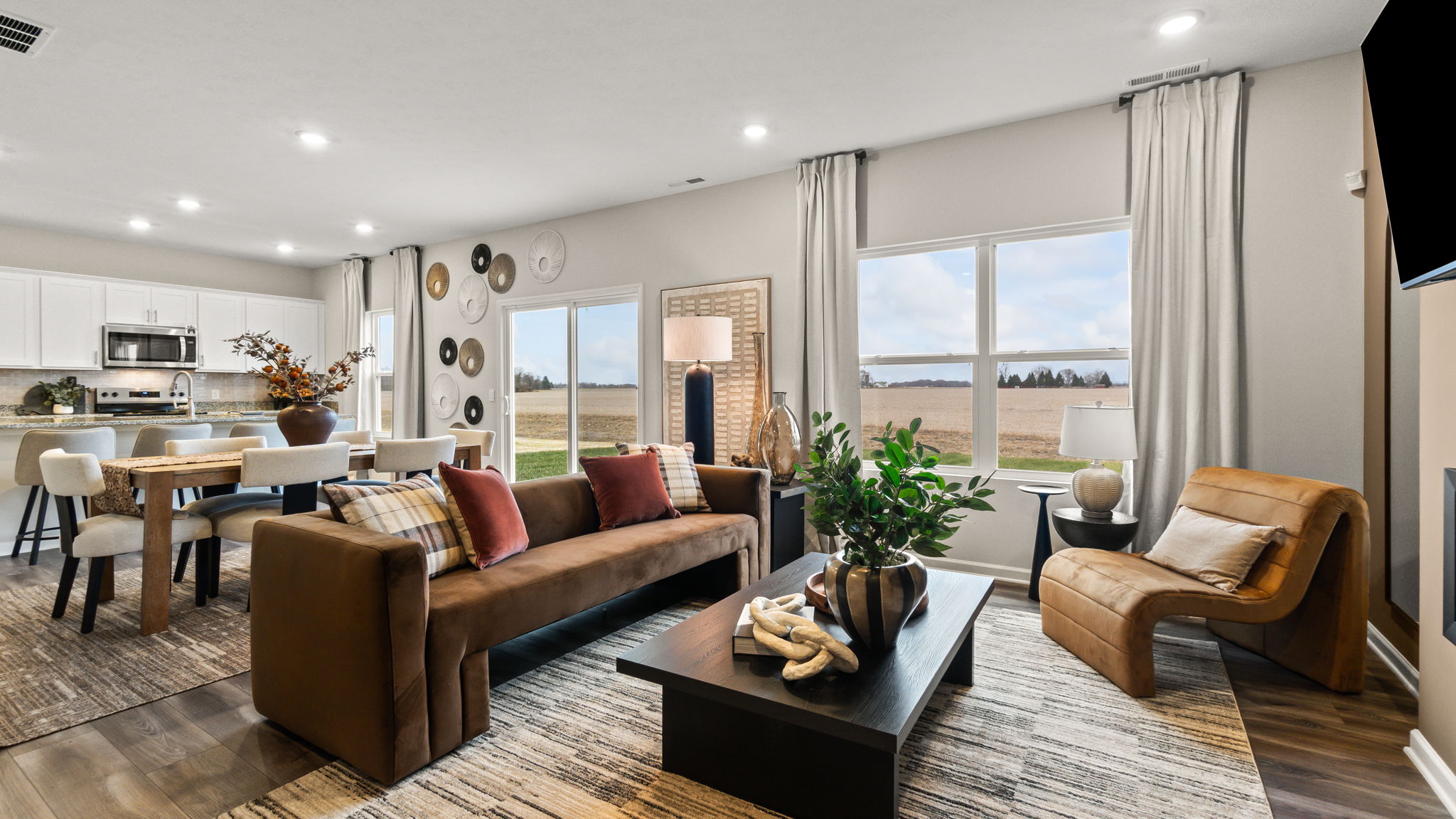 Full living room with windows, sliding door, and view of kitchen.