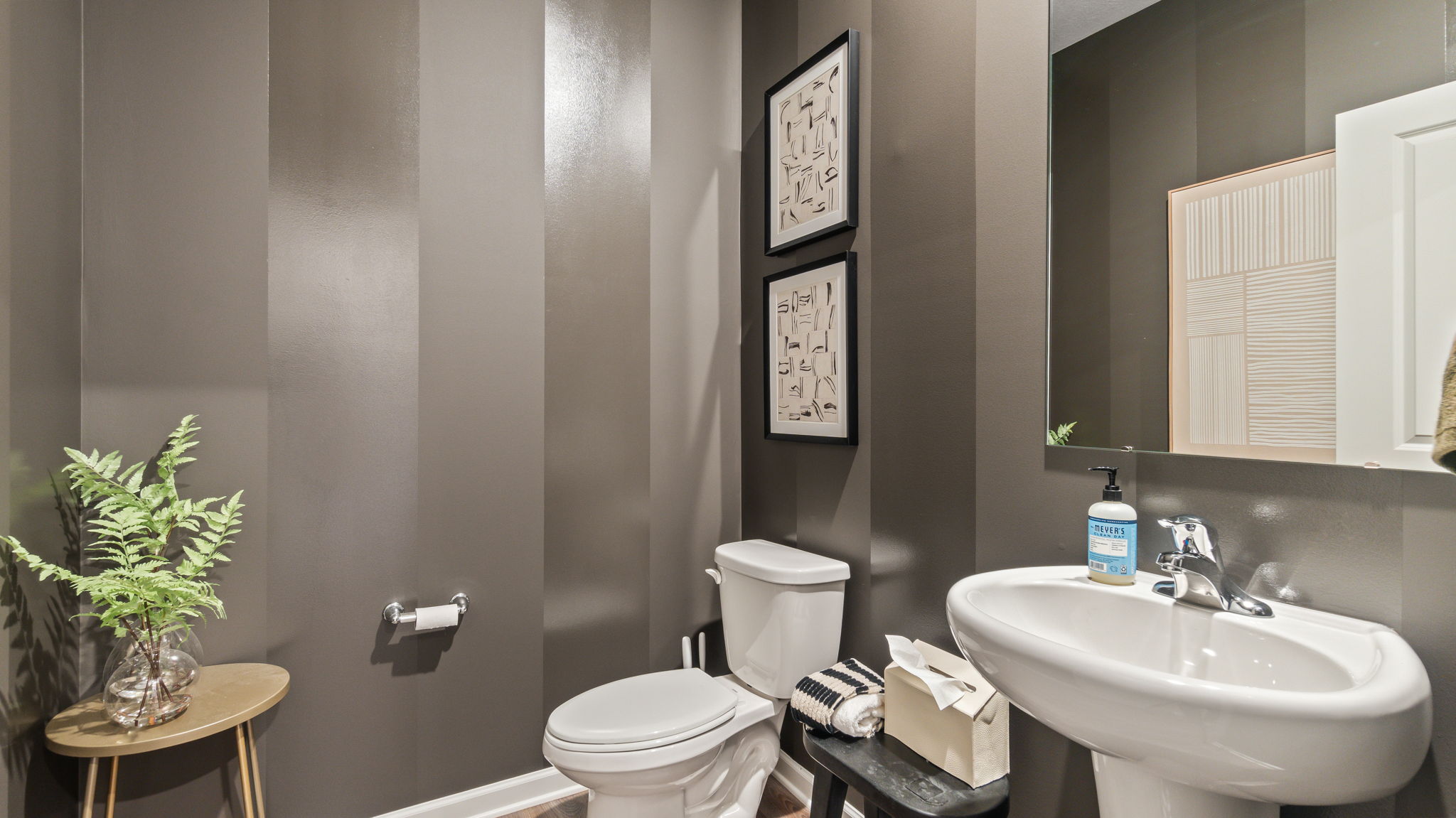 Powder room with contrasting matte/gloss gray wallpaper, toilet, sink, and mirror.
