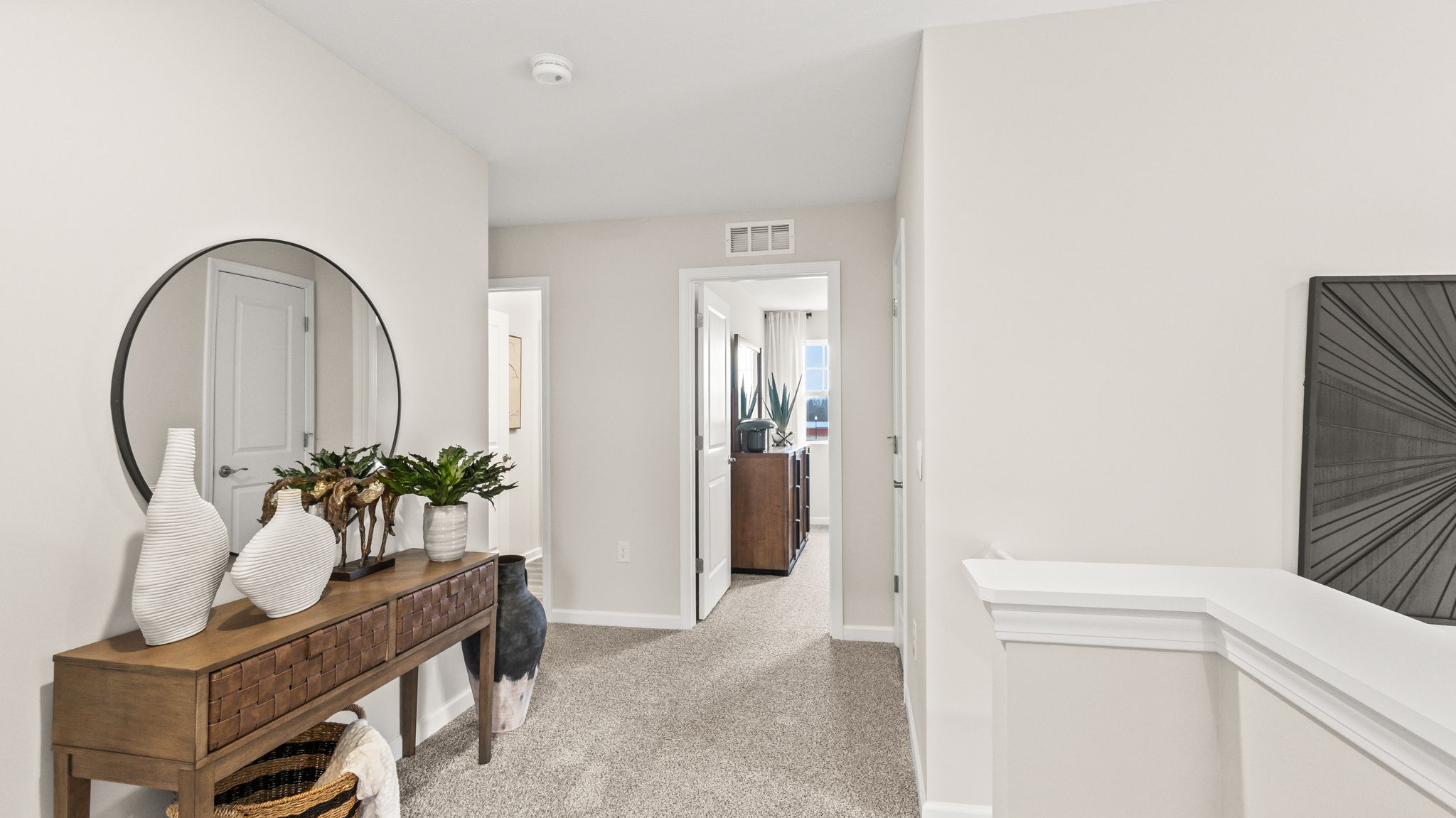 Upstairs landing with wooden table, mirror, and curios.