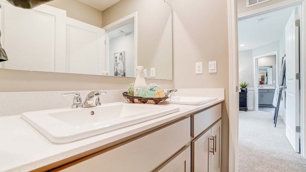 dual vanity sinks with view into the hallway.