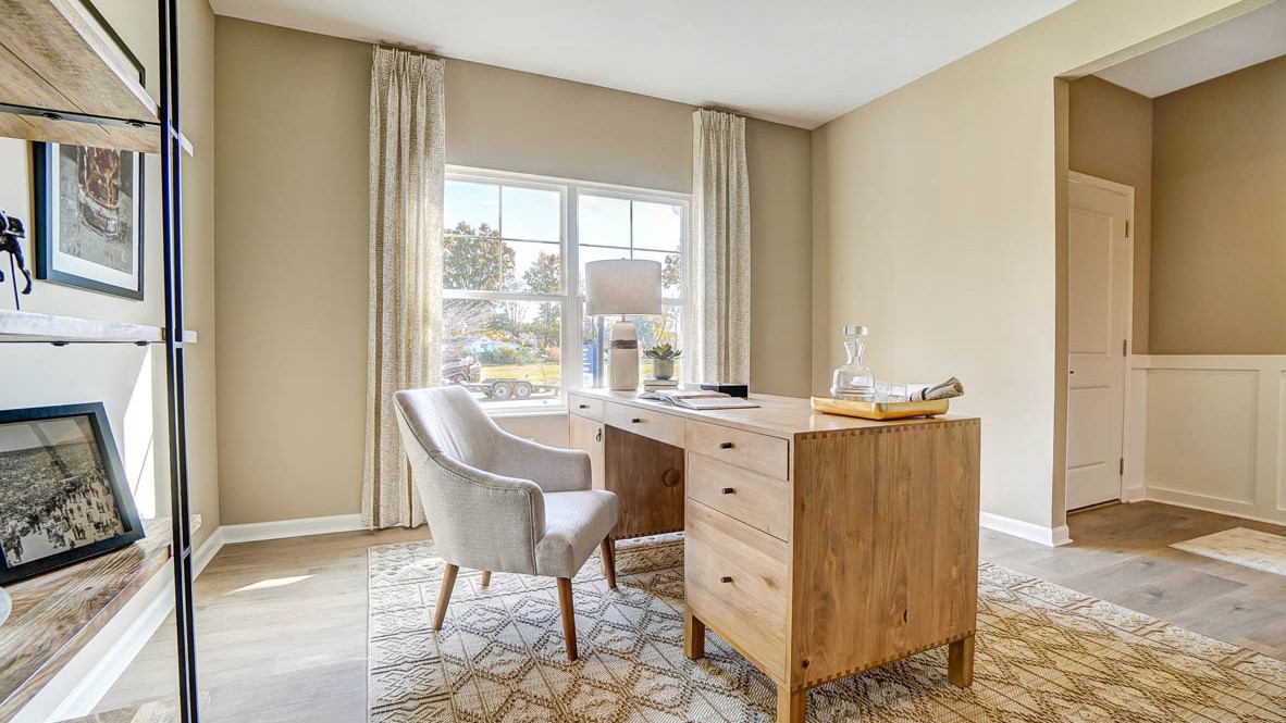 Wooden desk with large windows on the corner.