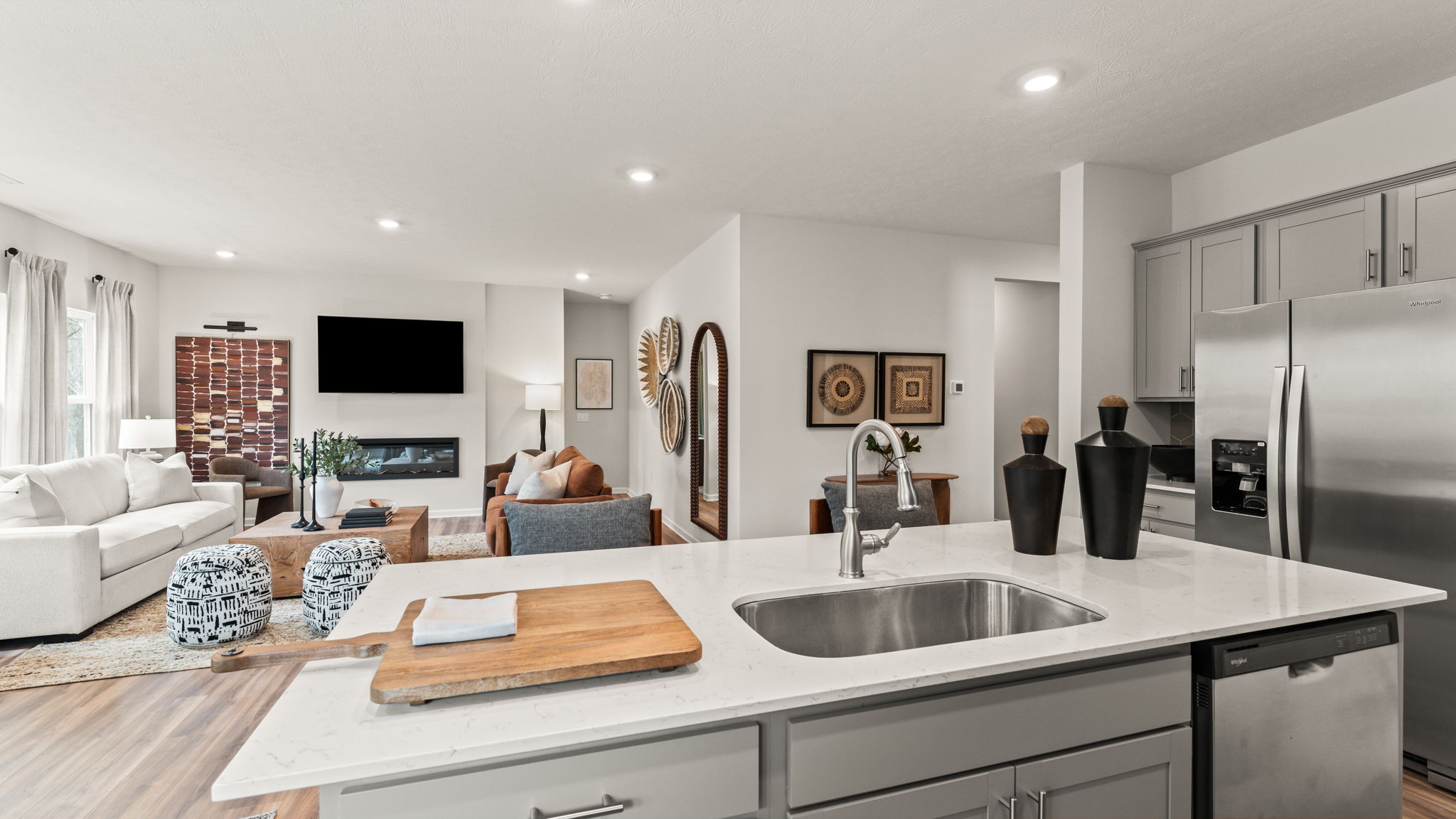 View of the open-concept kitchen and great room with contemporary art pieces on the walls and comfortable furniture