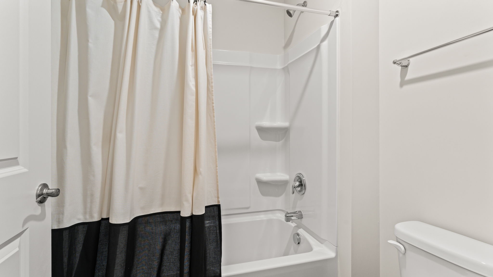 closeup of tub/shower combo with tiered shelving