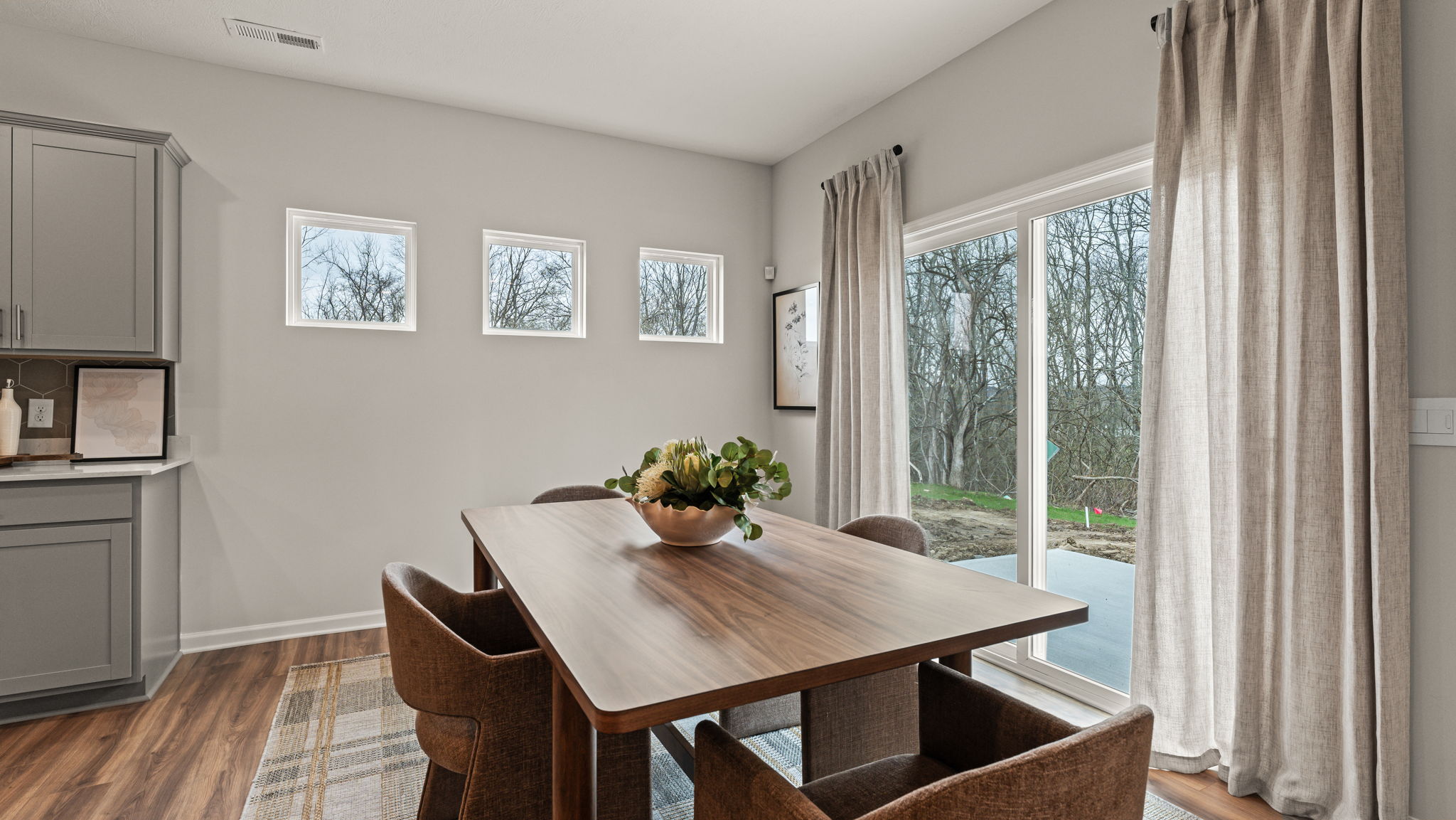 Closeup of dining area with deep brown wooden table, centerpiece bowl, and door to rear