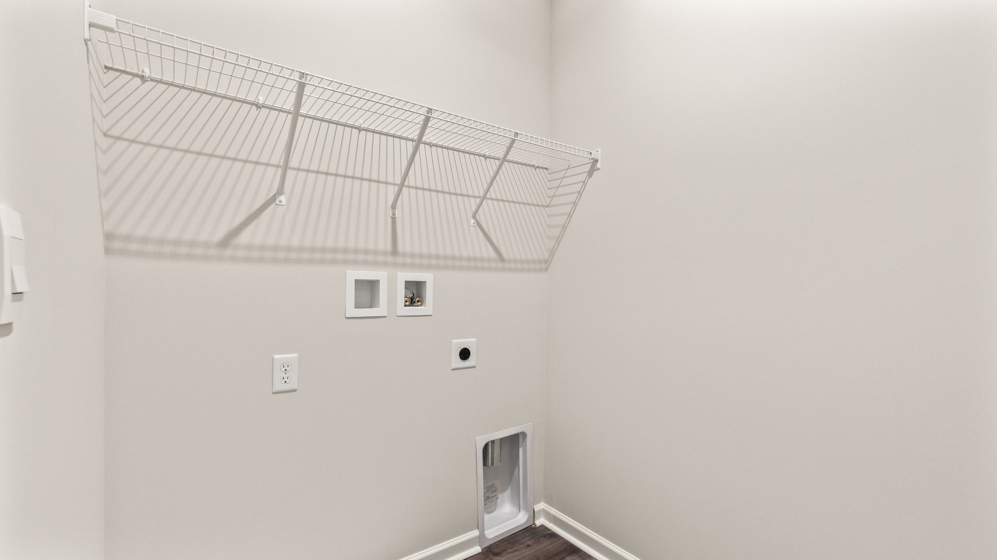 Laundry room with washer/dryer inlets and wire rack