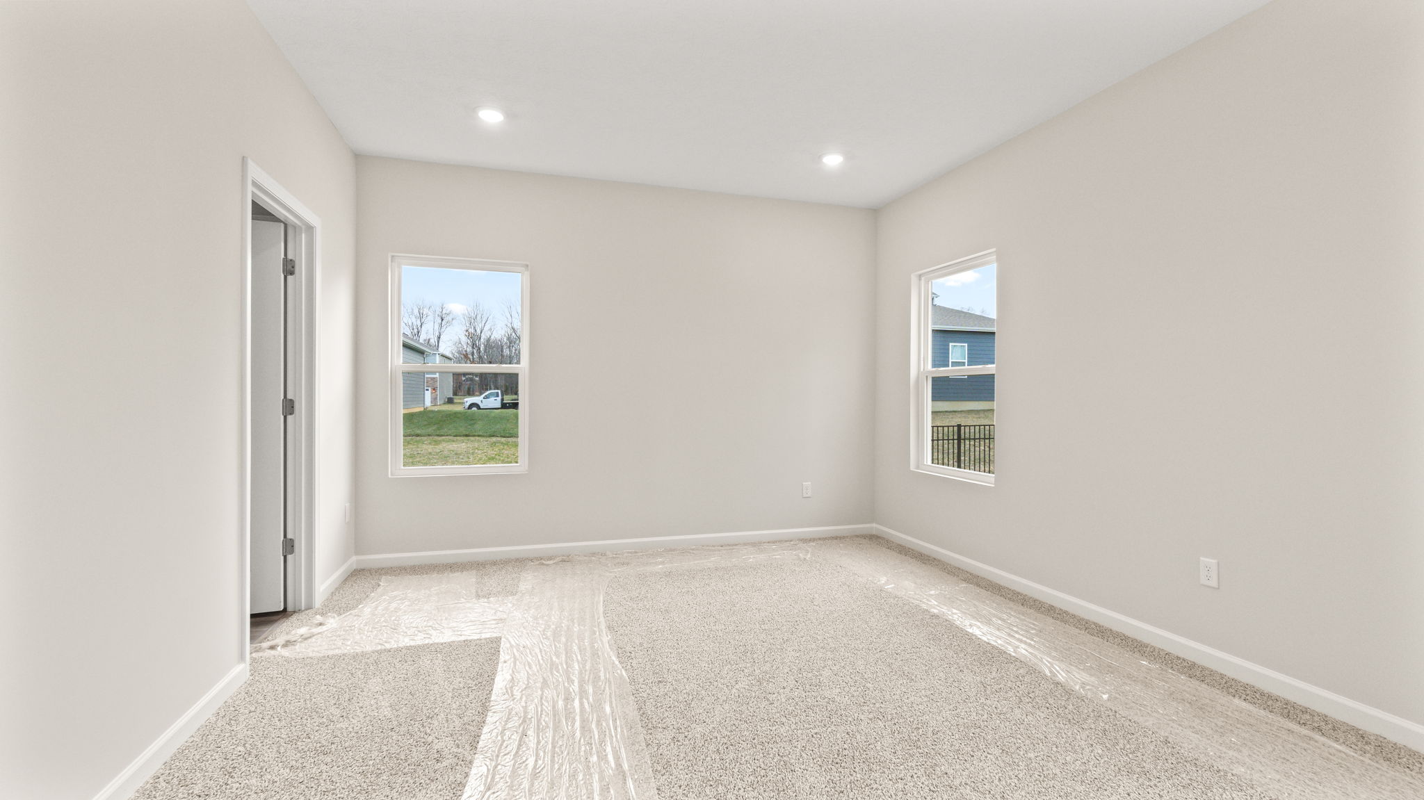 Carpeted primary bedroom with windows