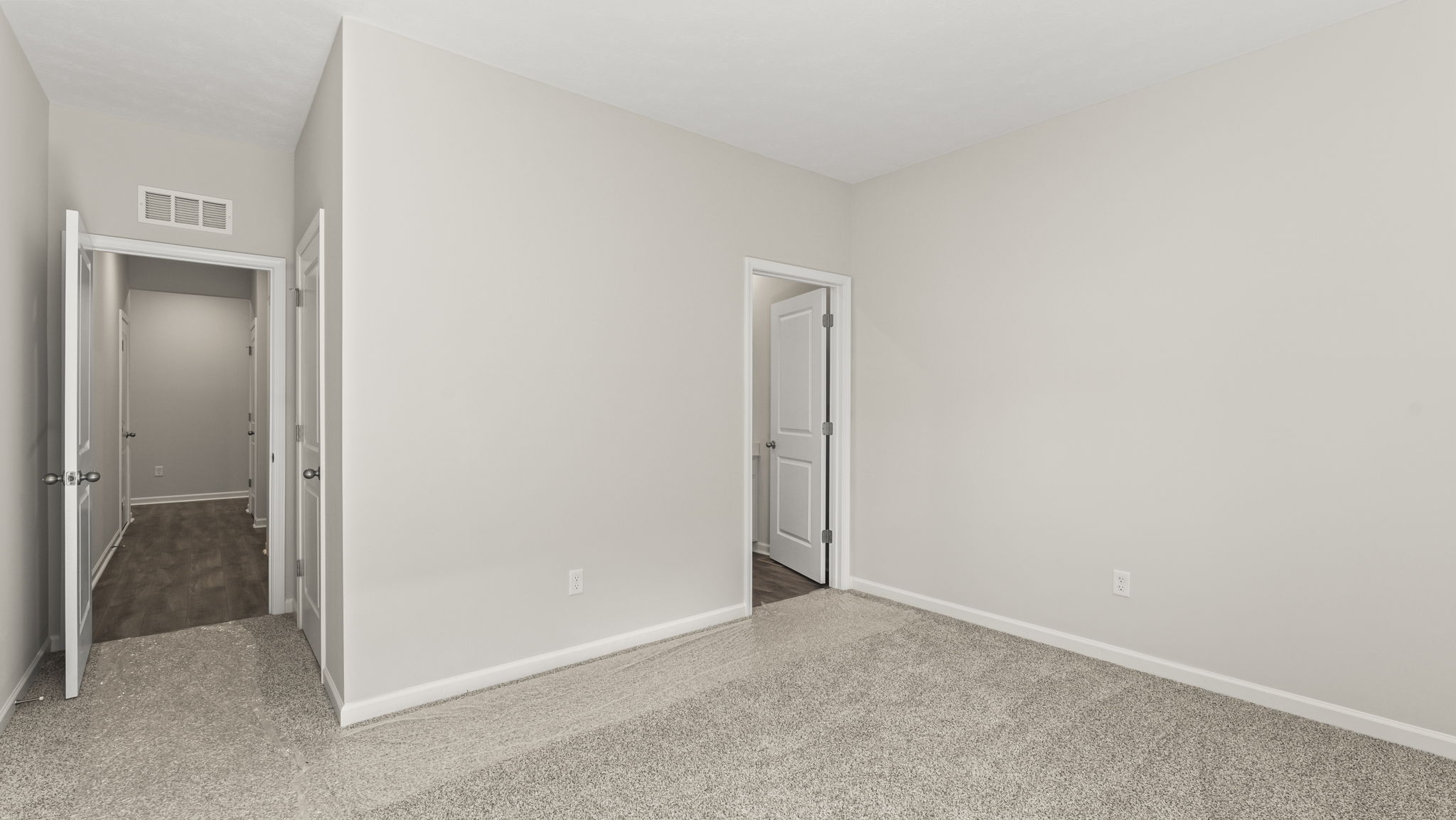 Carpeted bedroom with door to closet