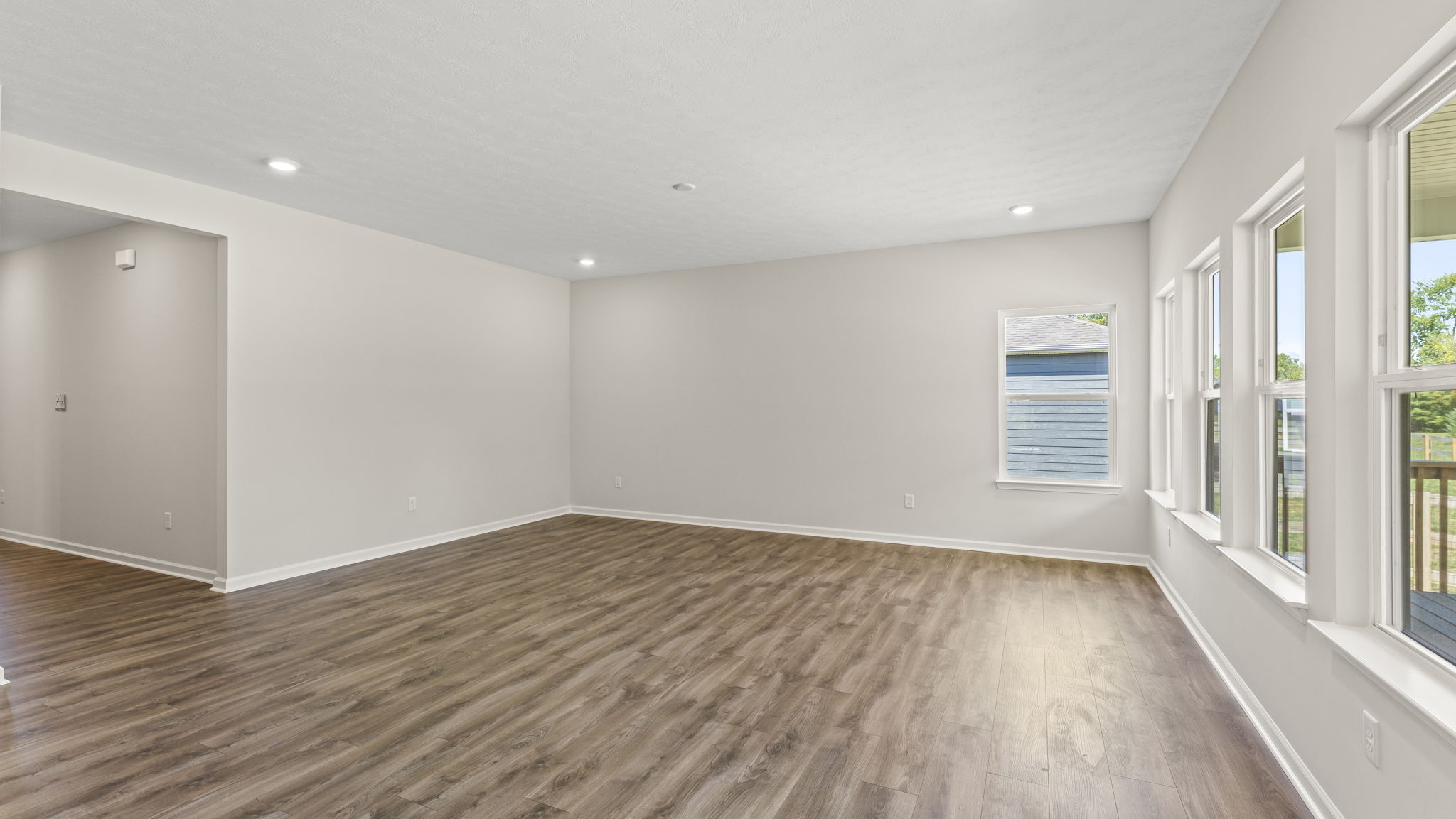 Full great room with windows and brown flooring