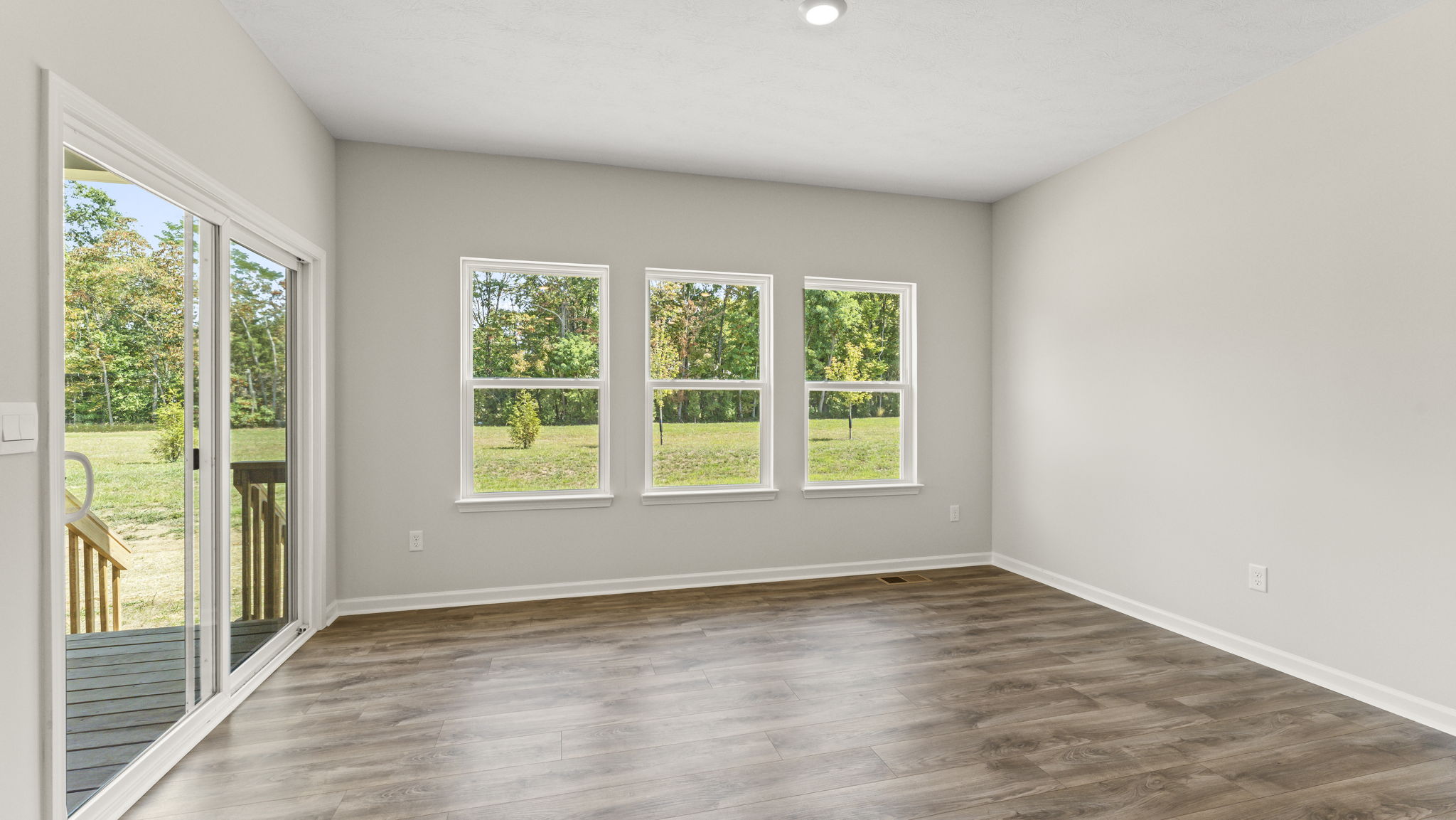 Dining area next to sliding door and three windows