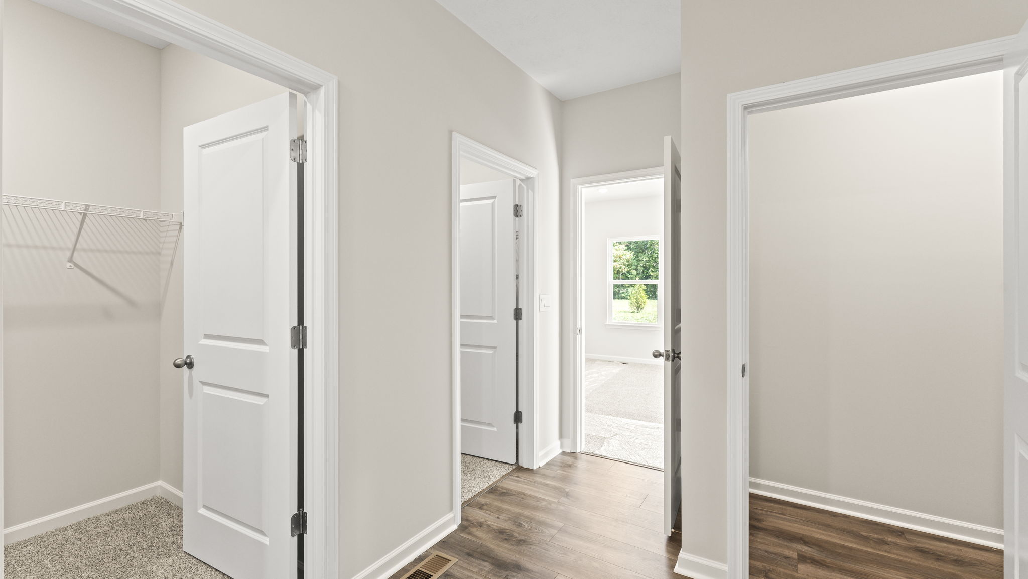Doors inside the bathroom suite leading to walk-in closet, toilet, and storage