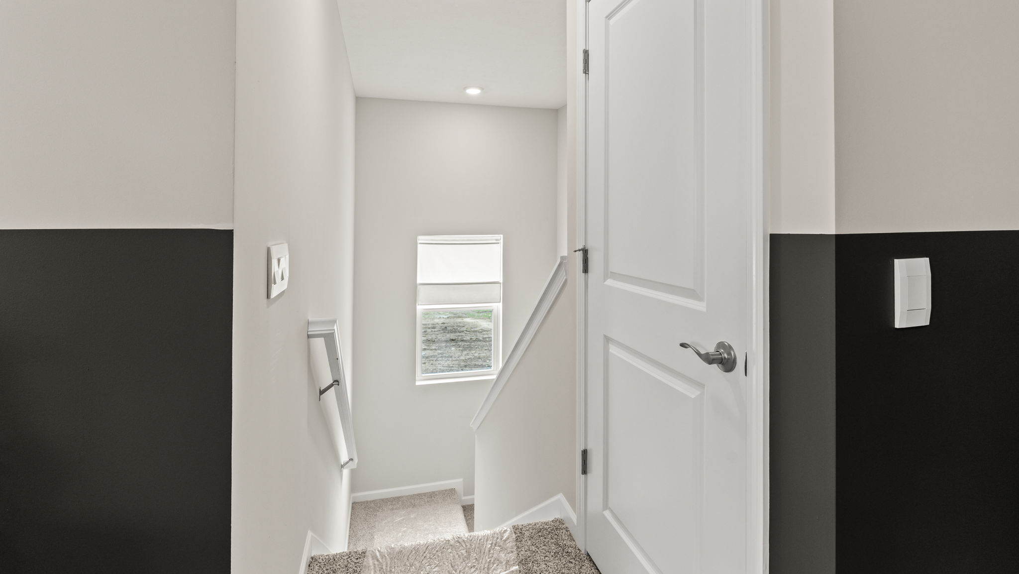 Upstairs landing with view of railing and two-tone walls