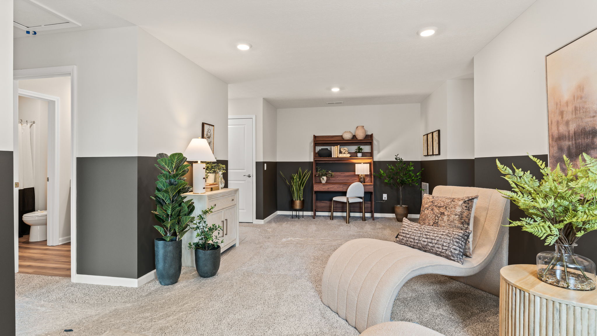 Cozily-arranged loft area with plants and lounge chairs