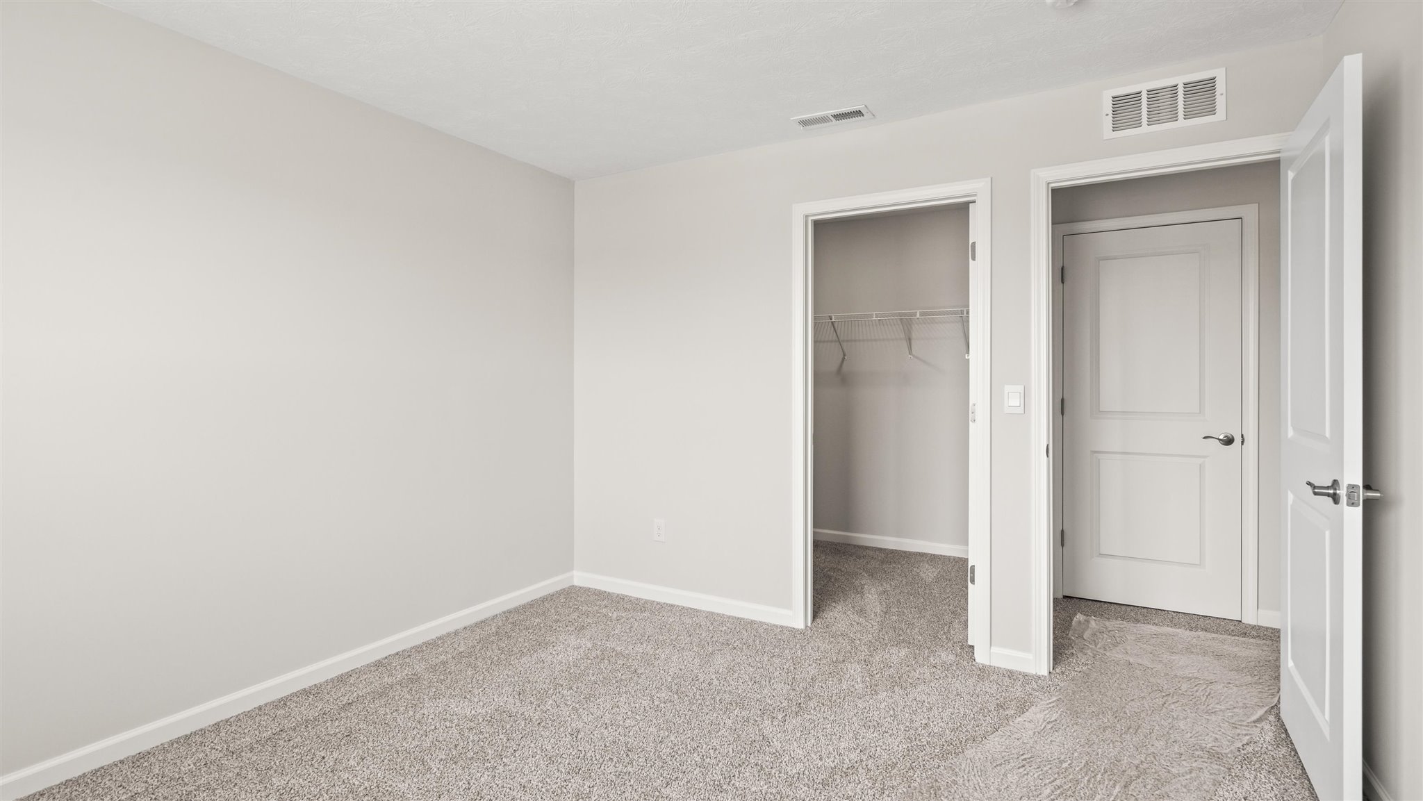 Bedroom with carpet, closet, and entrance to hallway