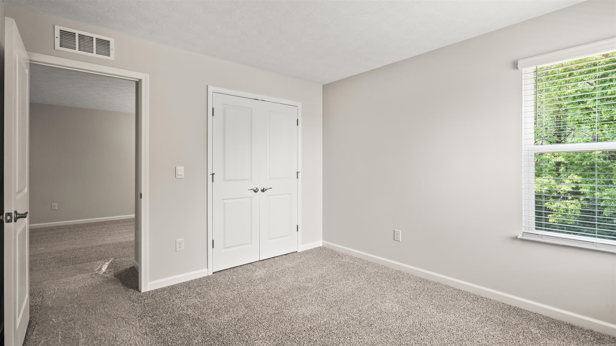 Bedroom with carpet, closet, and entrance to hallway