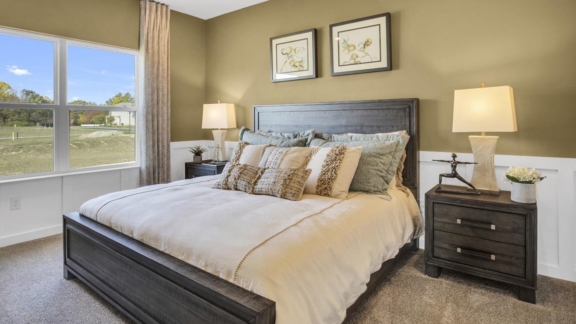 Primary bedroom with bedside tables decorated with beautiful lamps and modern art.