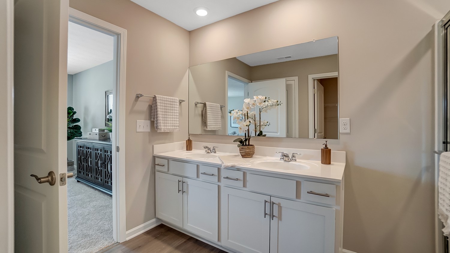 Primary bathroom with dual vanity sinks and large mirror.