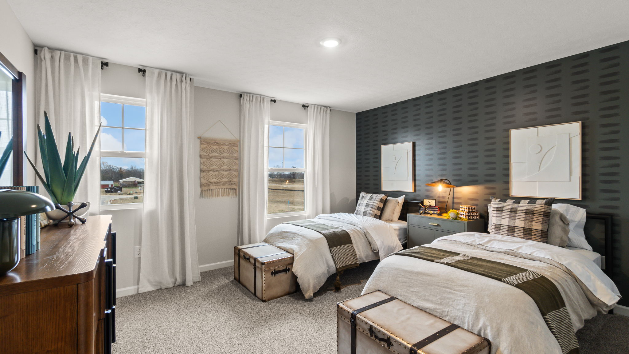 Bedroom 2 with twin beds, storage trunks, and black patterned wallpaper.