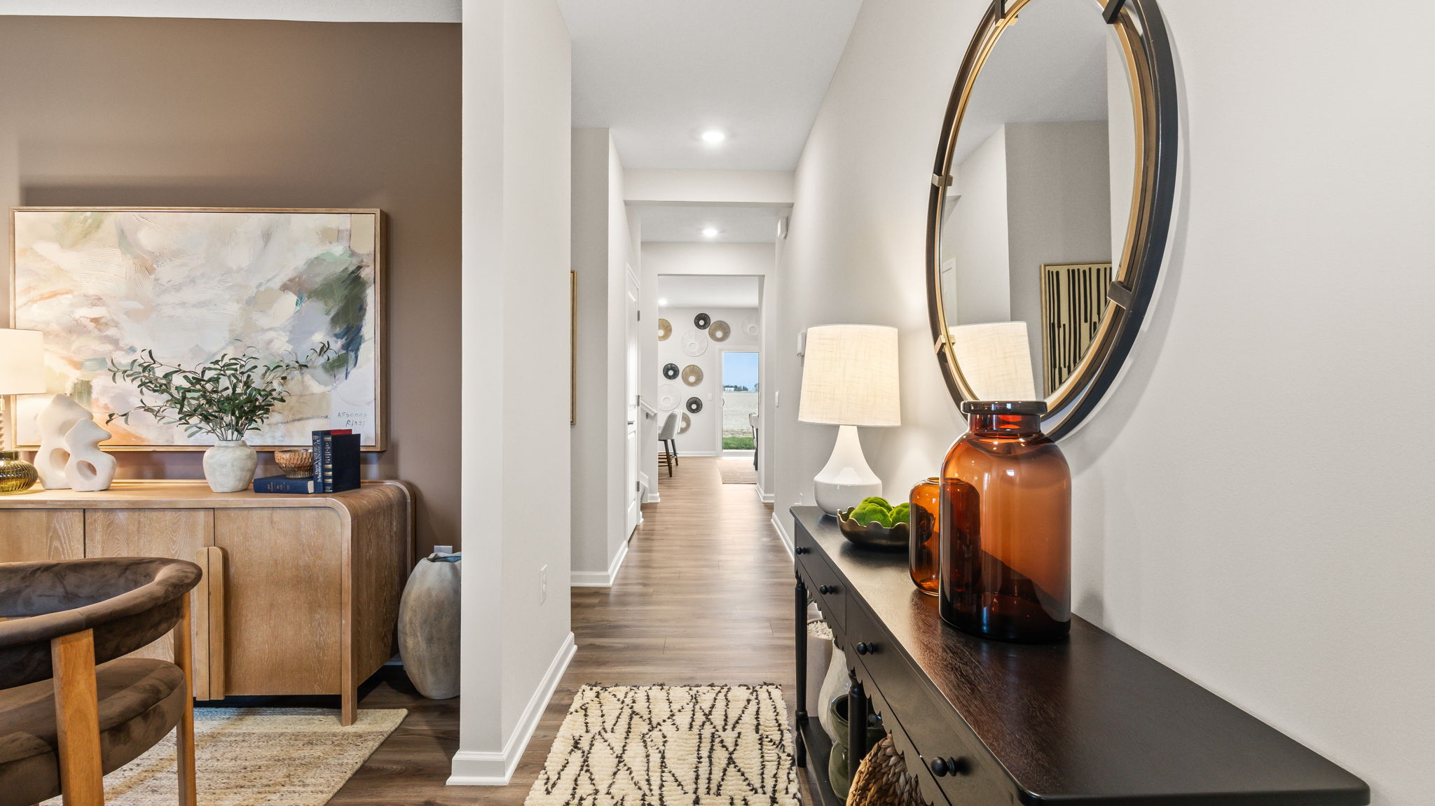 Front of hallway with modern decoration, mirror, table, and view into flex room as an office.
