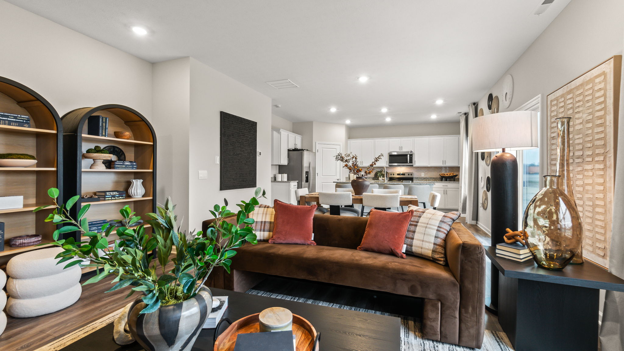 Lower-angle of living room with bookshelves, plants, and contemporary couch.