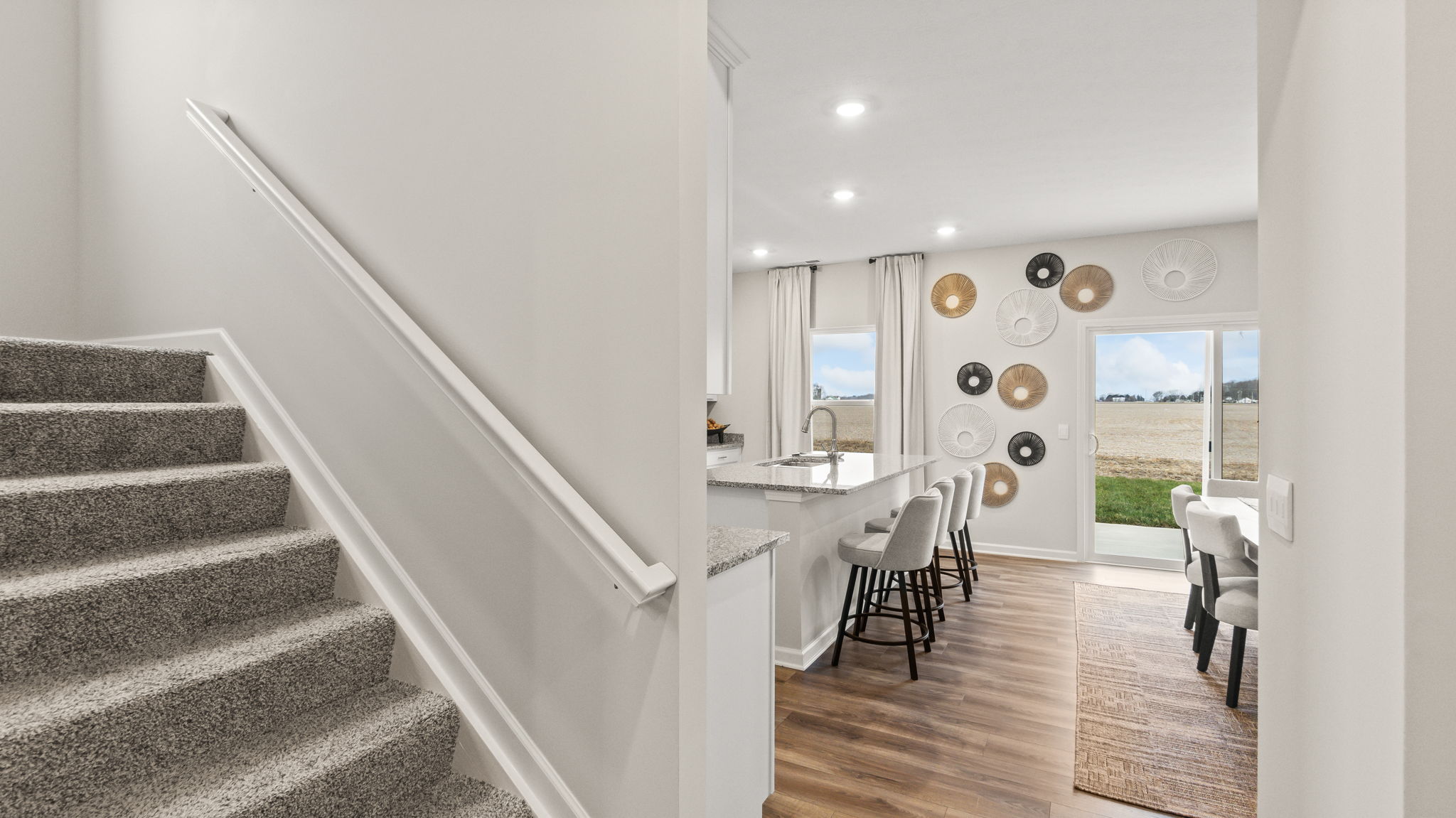 Stairs leading to second floor on the left and kitchen on the right.