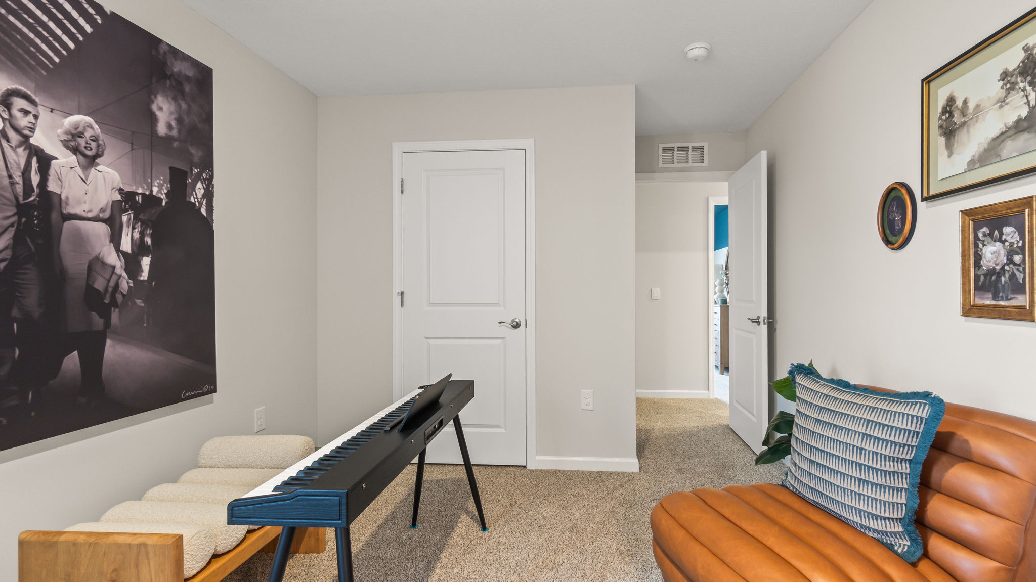 Bedroom 4 dressed as a music room with keyboard piano, chairs, and print art on walls.