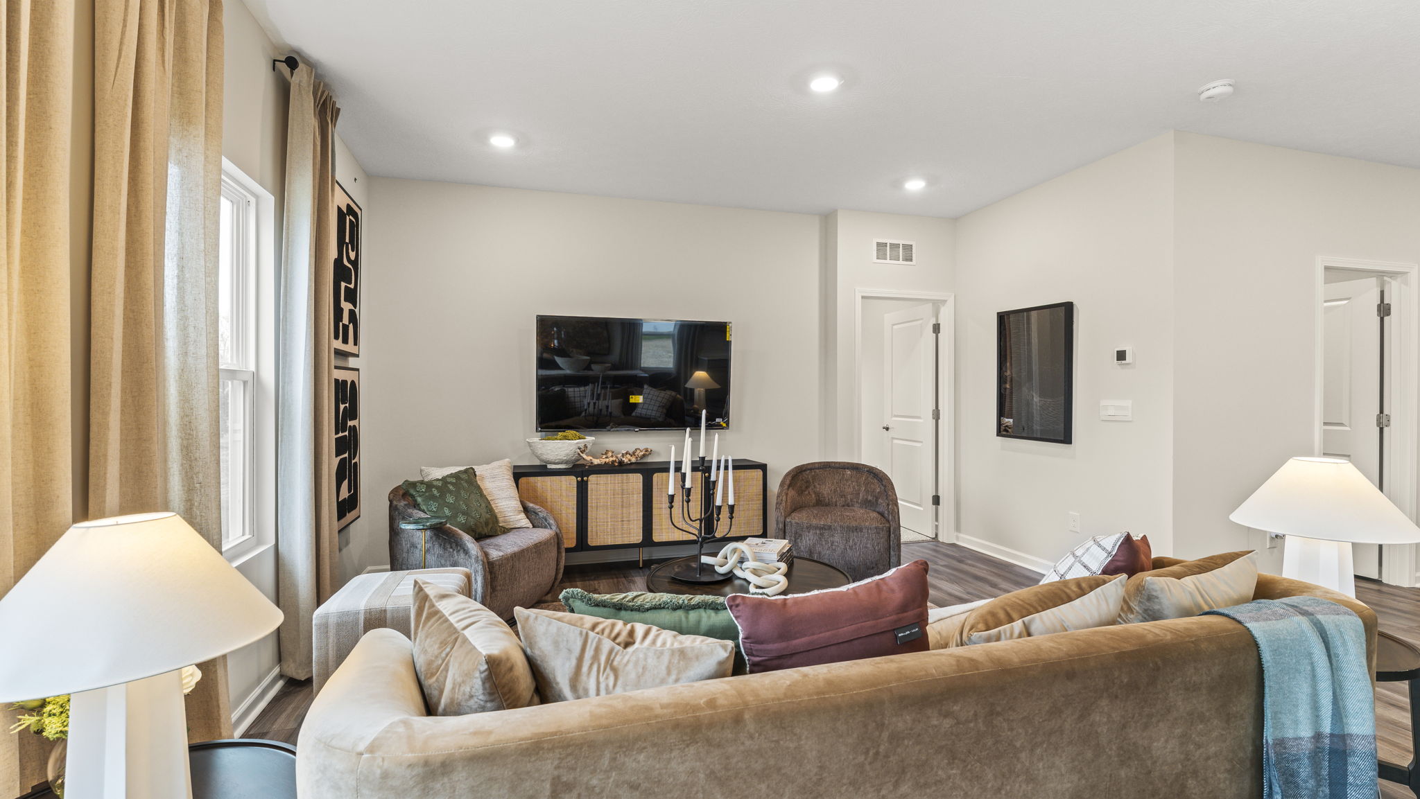 Full living room with brown and earthy furniture, entertainment area, and coffee table centerpiece.