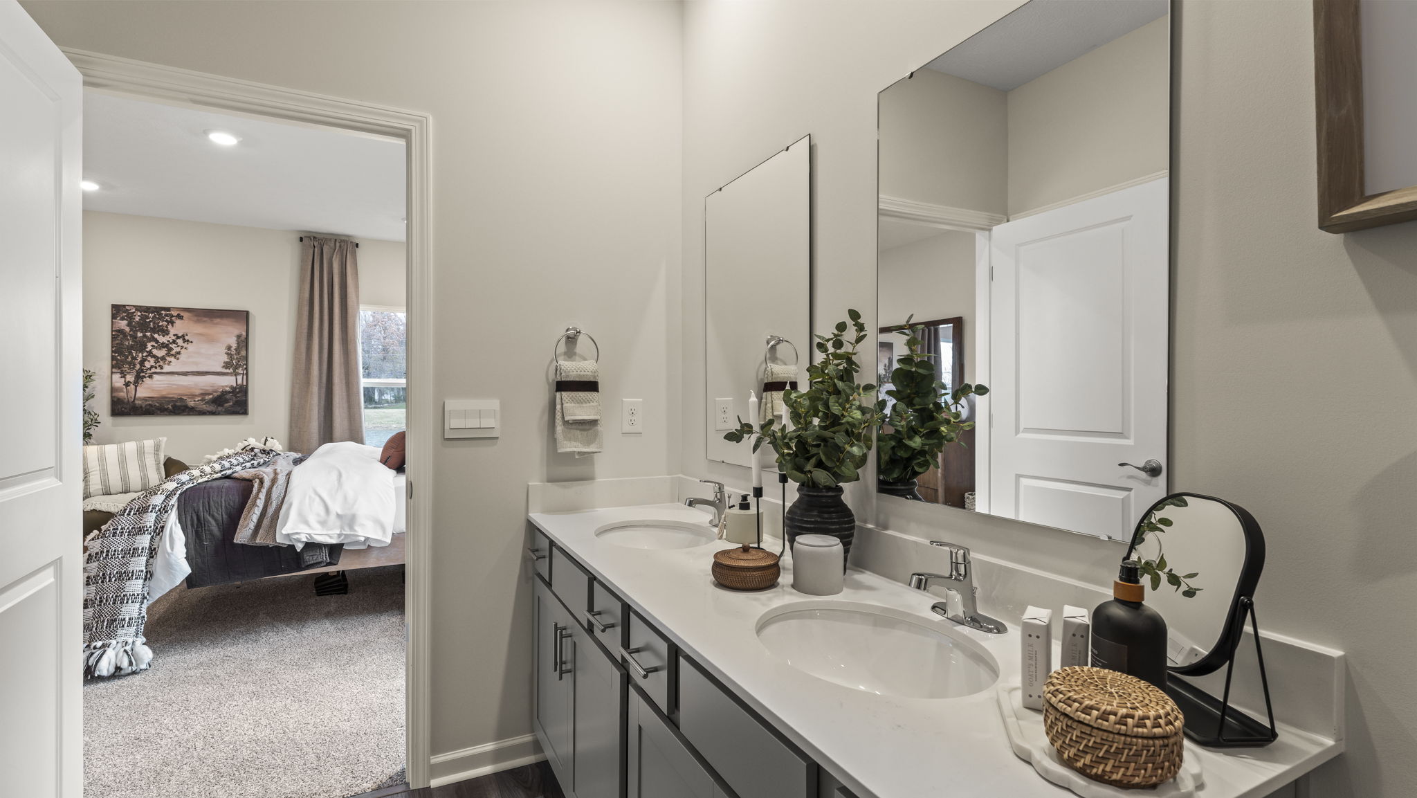 Closeup of dual-vanity with plant, candles, and soaps.