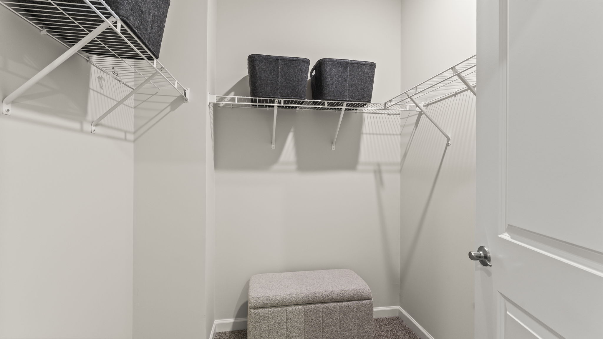 Walk-in closet with storage bins and wire shelving.