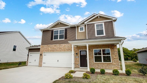 two story home with brown siding, partial stone front, covered front porch, three car garage