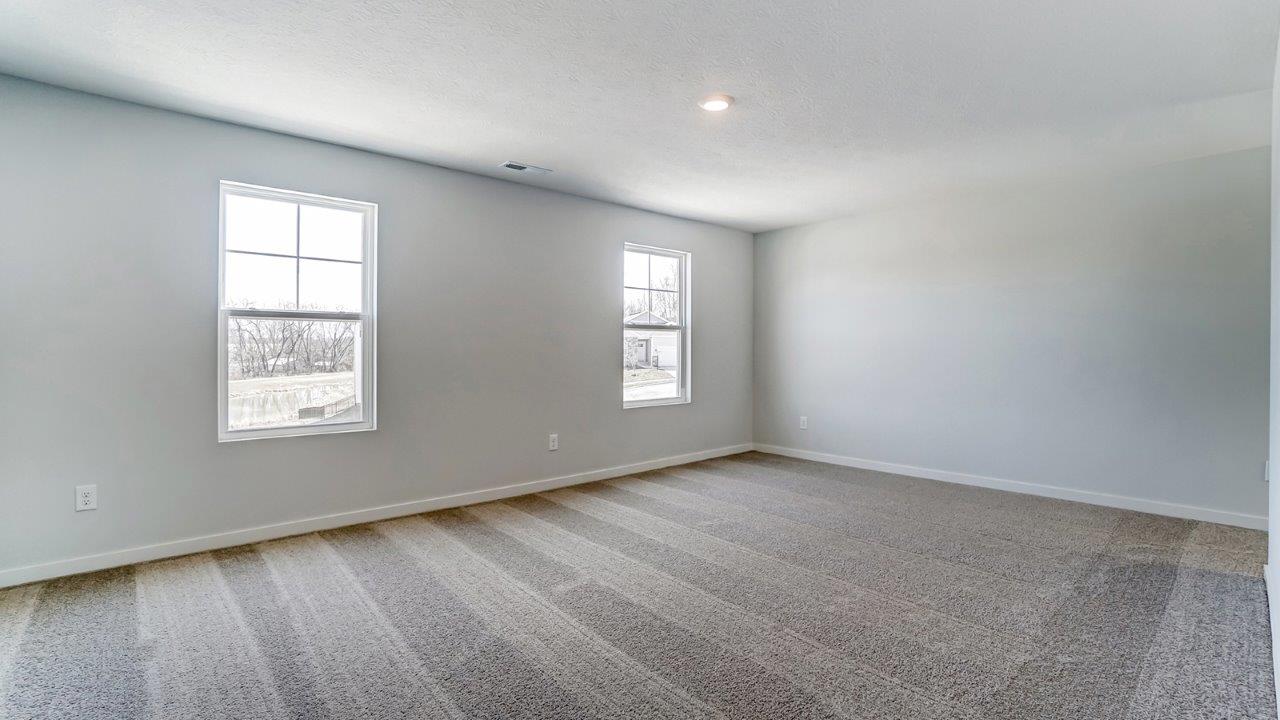 Interior primary bedroom with windows