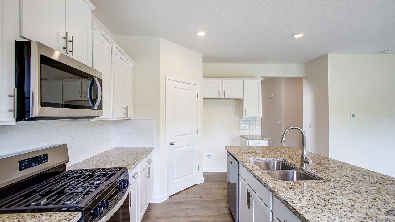 white kitchen cabinets, stainless steel appliances, hard surface counters, walk in pantry