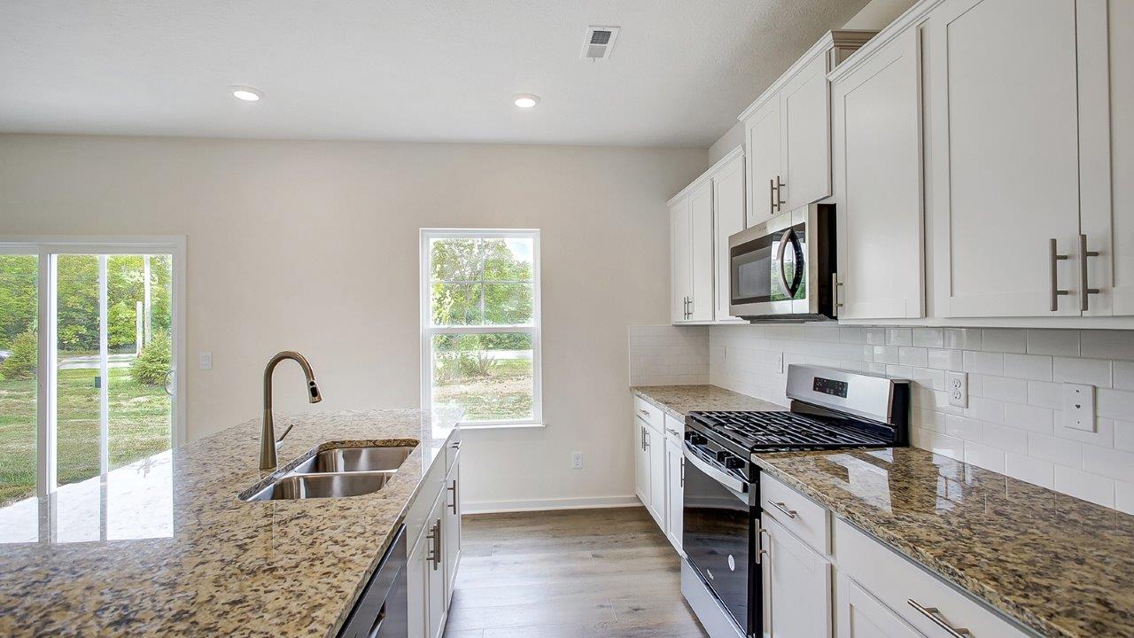 white kitchen cabinets, stainless steel appliances, hard surface counters, single window