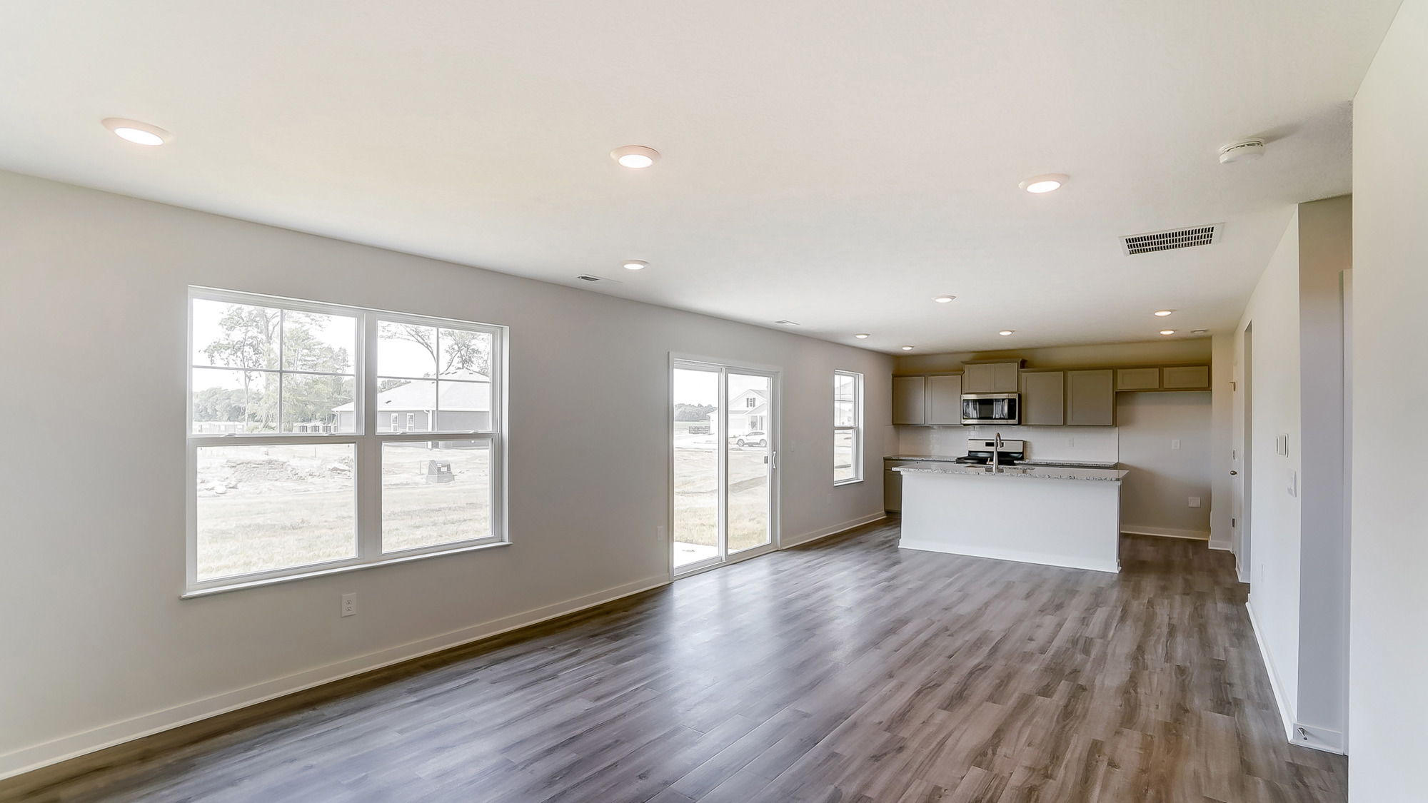 great room with double window, rear sliding door and kitchen