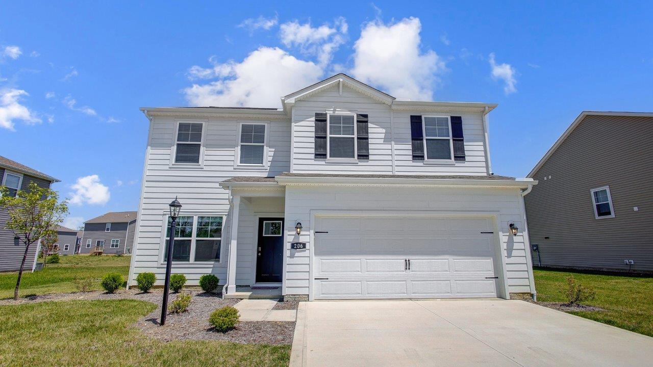 two story home with white siding, covered entry and two car garage