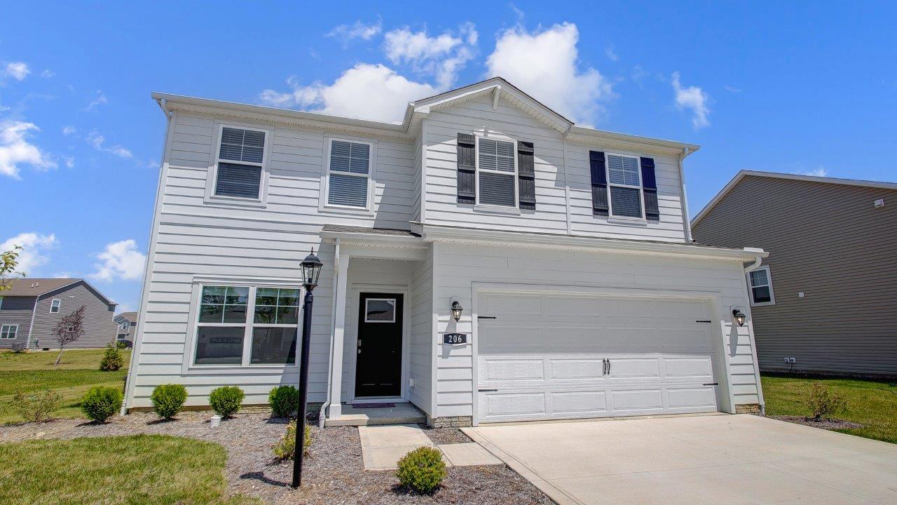 two story home with white siding, covered entry and two car garage