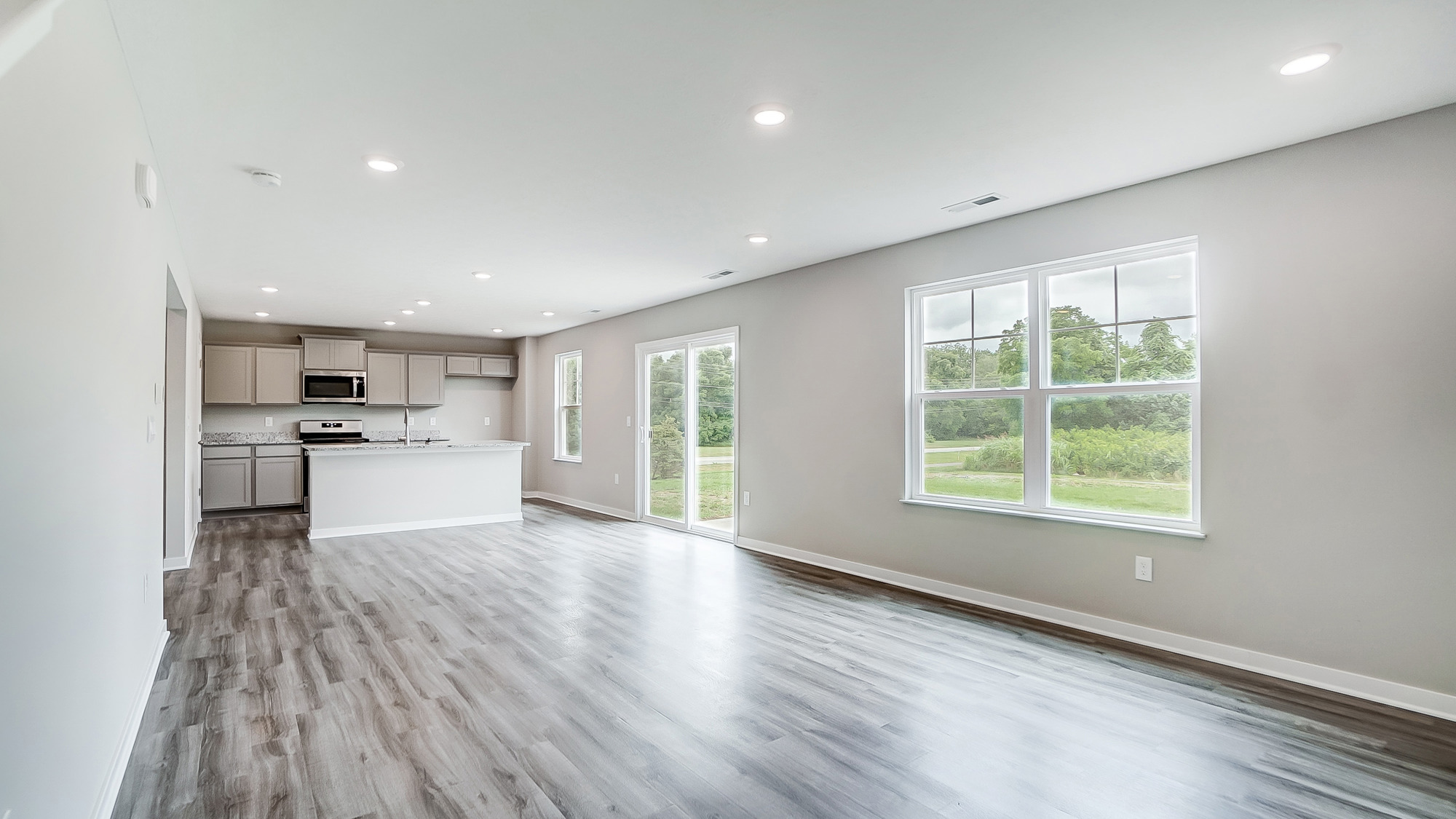 great room with double window, rear sliding door, kitchen